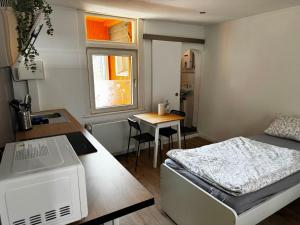 a small room with a bed and a desk and a table at Wohnen auf Zeit in Hückeswagen -Neu- in Hückeswagen