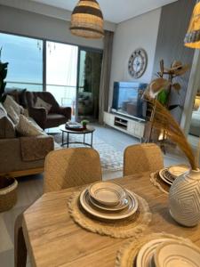 a living room with a wooden table with chairs at شقة فاخرة بإطلالة بحرية في داماك in Jeddah