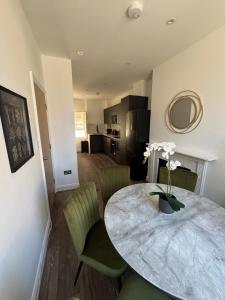 a kitchen and dining room with a table and chairs at Cosy Townhouse In Central London in London