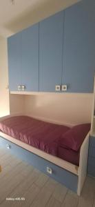 a bed in a room with blue cabinets at appartamento sapore di mare in Pozzallo