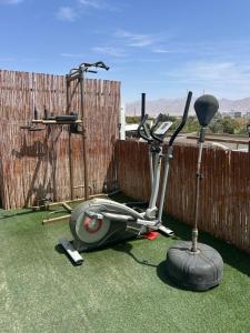a moped parked on the grass in front of a fence at Roof top glamping and Toys suites in Eilat