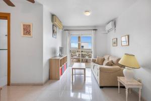 サン・ペドロ・デル・ピナタルにあるMarina Vibes apartment with poolのソファとテーブルのあるリビングルーム