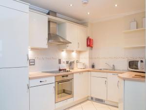 a kitchen with white cabinets and a microwave at Oakdale at Centrium in Woking