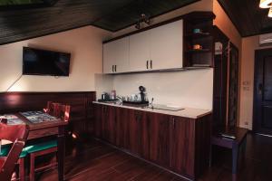 a kitchen with wooden cabinets and a table and a counter at Shoemaker Irish Pub & Accommodation in Kielce