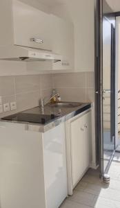 フロワラックにあるNid'ZEN Floirac près de Bordeauxの白いキッチン(シンク、カウンター付) +7枚の写真