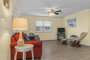 a living room with a red couch and a table at Boardwalk Shores A Duplex in Atlantic Beach