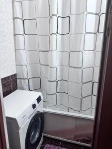y baño con ducha y lavadora. en House, en Aktobe