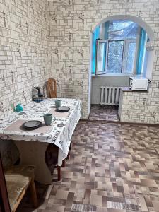 una habitación con una mesa con platos. en House, en Aktobe