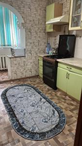 una cocina con una alfombra grande en el suelo en House, en Aktobe