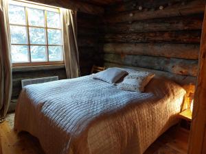 a bedroom with a bed in a log cabin at Kotkas in Syöte