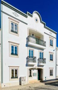 a white building with balconies on it at Rio Gilao in Tavira