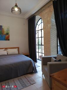 a bedroom with a bed and a couch and a window at Résidence Tozeur Almadina chambres Supérieures in Tozeur