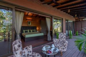 a bedroom with a bed and a table and chairs at SaffronStays Timber Quest - Pinewood Cottages in Dehradun +37 photos