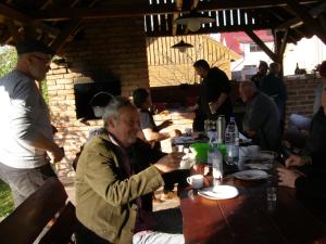 a group of people sitting around a wooden table at Pension Harmonia in Miercurea-Ciuc