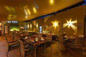 a restaurant with tables and chairs and lights on the wall at Trisan Resident Hotel in Nairobi +119 photos