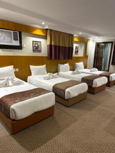 a group of four beds in a hotel room at فندق المغاربي للشقق الفندقية in Al Madinah