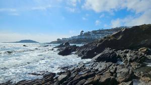 a view of the ocean from a rocky beach at Talland Cottage 4 bedroom with Hot Tub in Looe