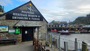 a building with a marina with boats in the water at Lanreath Cottage 3 bedroom with Hot Tub in Looe