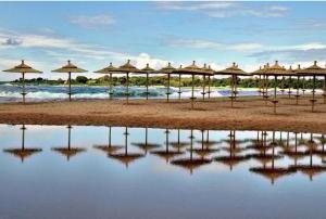 a group of umbrellas on a beach next to the water at Agrilis Cottage near the beach in Ágrilos