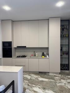 a kitchen with white cabinets and a marble floor at VILLA Kachreti Ambassadori Golf Resort in Kachretʼi
