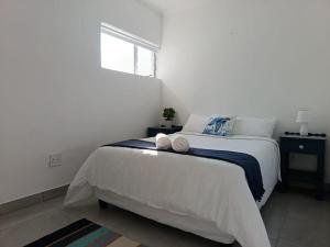 a bedroom with a bed with two towels on it at Hartsepunt in Mossel Bay