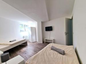 a white room with two beds and a tv at BS Monteurunterkunft BE1 in Bergisch Gladbach