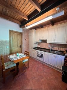 a kitchen with white cabinets and a wooden table at El Refugio de Júlia in Mier +13 photos