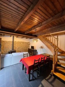 a dining room with a red table and chairs at El Refugio de Júlia in Mier