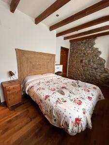 a bedroom with a bed and a stone wall at El Refugio de Júlia in Mier