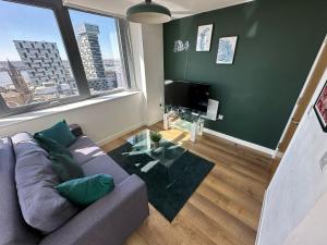 a living room with a couch and a glass table at Two Bedroom City View Apartment Liverpool in Liverpool