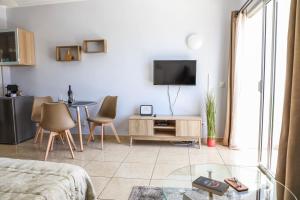 a living room with a table and a tv on a wall at Perla Paraisó in Playa Paraiso