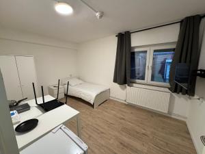a small room with a bed and a desk with a computer at Peters Gasthaus in Drochtersen