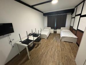 a room with two beds and a flat screen tv at Peters Gasthaus in Drochtersen
