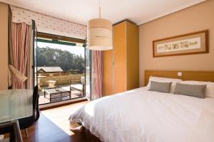 a bedroom with a large bed and a large window at Spacious Villa with Pool Plentzia Bilbao Area in Mendiondo