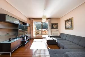 a living room with a couch and a tv at Spacious Villa with Pool Plentzia Bilbao Area in Mendiondo