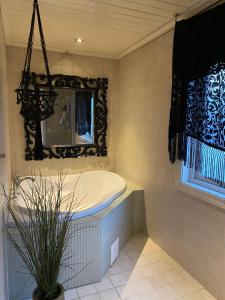 ein Badezimmer mit Badewanne und Spiegel in der Unterkunft Skien Villa in Skien