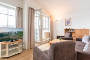 ein Wohnzimmer mit Couch und Fernseher in der Unterkunft Seepark Sellin FeWo AG Whg 383 in Ostseebad Sellin