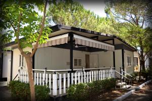a house with a white fence in front of it at Villaggio Mondial Camping in Metaponto