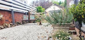 a garden with potted plants and a brick wall at 'The Den' - Malvern - A King Size or Twin Beds plus a Sofa Bed in Great Malvern