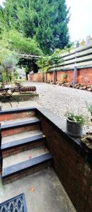 a set of stairs next to a brick wall at 'The Den' - Malvern - A King Size or Twin Beds plus a Sofa Bed in Great Malvern