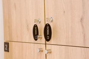 two black doors with handles on a wooden cabinet at Top view hostel in Durrës
