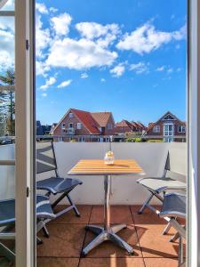 un tavolo e sedie su un balcone con vista di Nordseeluft a Greetsiel