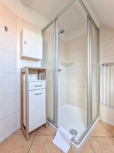 una doccia con una porta in vetro in un bagno di Nordseeluft a Greetsiel Altre 14 foto