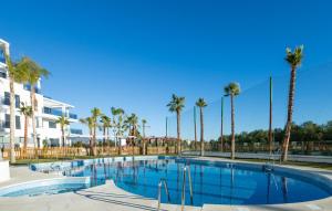 a swimming pool with palm trees in a resort at LM APARTAMENTOS Aguacate Costa Tropical in Motril