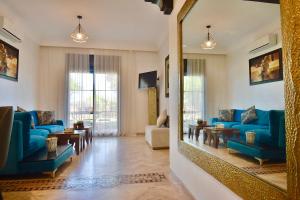 马拉喀什Oasis de l'Atlas by Golf Resort的客厅配有蓝色的沙发和镜子