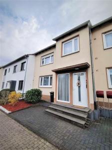 a house with a white door on a street at Rhein Ferienwohnung 3-Zimmer Garten Free Parking Netflix Premium Disney Premium in Koblenz