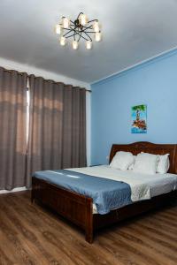 a bedroom with a large bed with a ceiling fan at Eastern Hills Apartments in Accra +25 photos