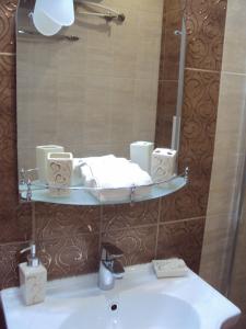 a bathroom with a sink with a mirror and a sink at Apartment Alyosha in Burgas City