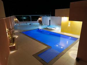 a large swimming pool in a house at night at شاليه الاميرات in Sowayma