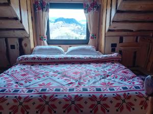 a bed in a room with a quilt on it at Casa rustica in Braşov